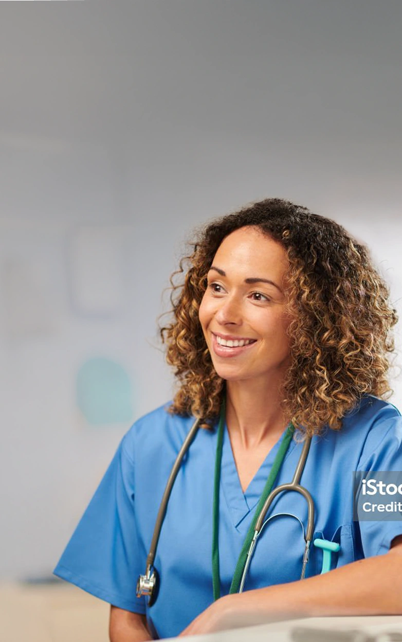 A female nurse helps an elderly patient up stairs in a home.