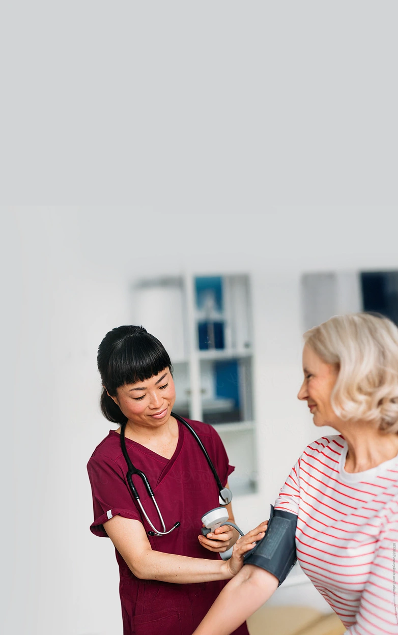 A nurse smiles while looking at a chart.