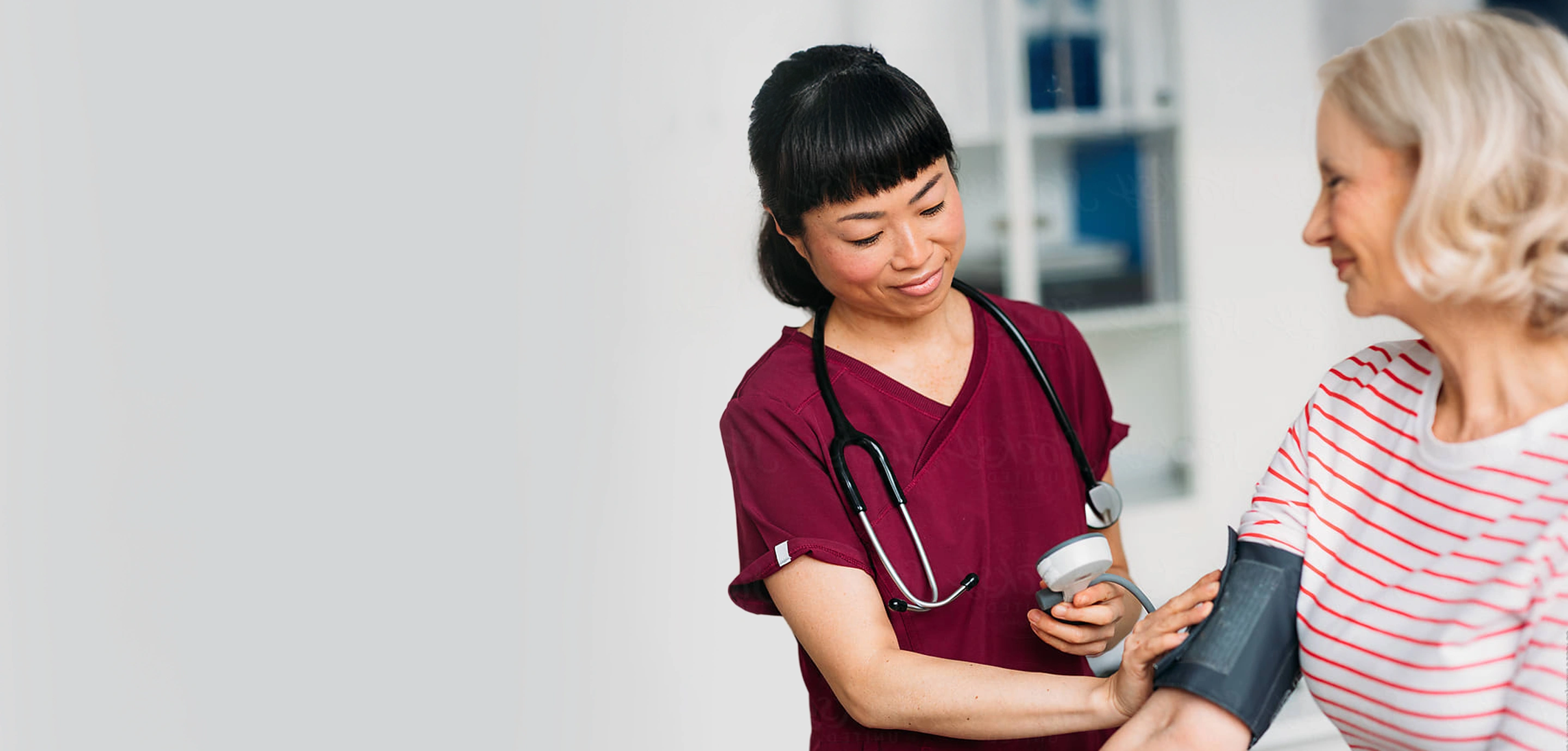 A nurse smiles while looking at a chart.